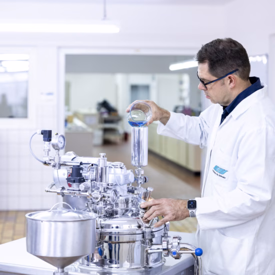 A laboratory technician uses stainless-steel processing equipment in a modern research center, where he performs precision tests, optimizes processes, ensures quality control, and conducts scientific analyses using state-of-the-art technologies.