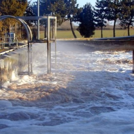 Un bassin d'aération avec de l'eau mousseuse, faisant partie d'un processus de traitement des eaux.