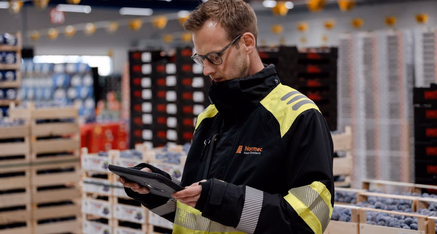 Lagerarbeiter mit Handscanner überprüft Waren in einer logistischen Umgebung.