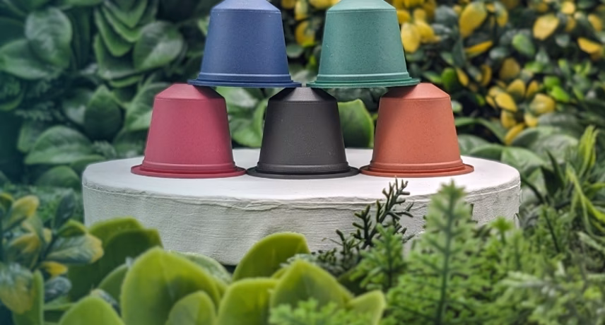 Five colorful jars stacked on a white background in a green setting, as an example of innovative and sustainable product development.