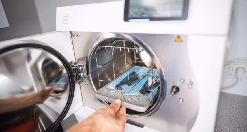 A laboratory technician places materials in an autoclave for sterilization as part of quality assurance, laboratory processes, and safe testing environments.
