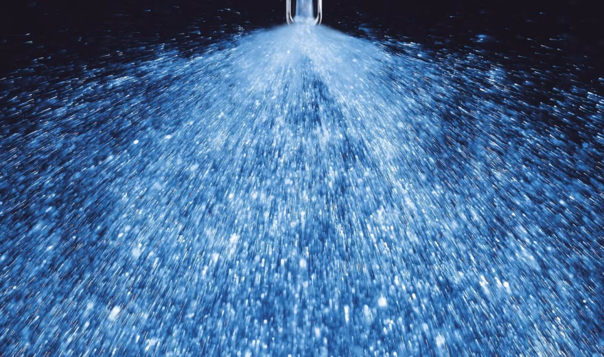 Waternevel uit een sproeikop tijdens een industriële reinigings- of productieproces.