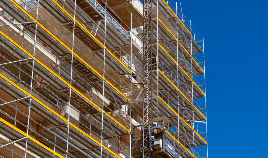 Structure d'échafaudage autour d'un bâtiment en construction pour les travaux sur la façade et les étages supérieurs.