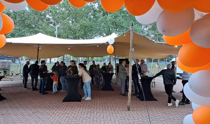 Ballonnenboog bij entree Normec Kalsbeek met medewerkers op de achtergrond