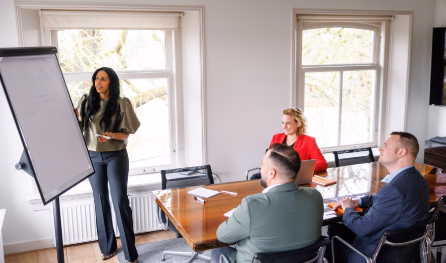 Teamoverleg in een kantoorruimte waarbij een presentatie over de WTTA wordt gegeven aan collega’s.