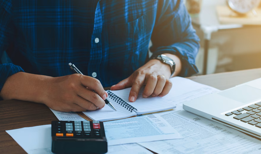 Man doing finances and calculate about cost to real estate investment and in other, tax system.Time for Taxes Money Financial Accounting Taxation Concept
