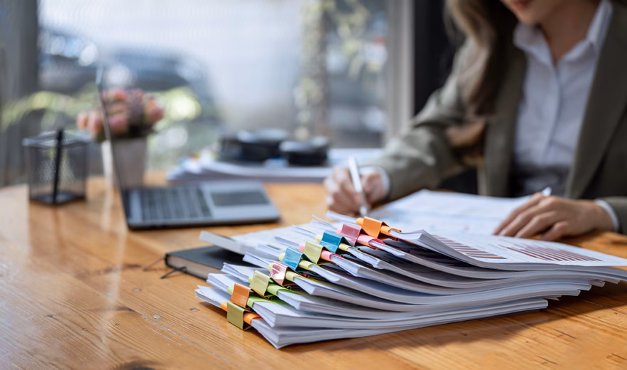 Business Documents concept : Businesswoman working in Stacks of paper files for searching and checking unfinished document achieves on folders papers