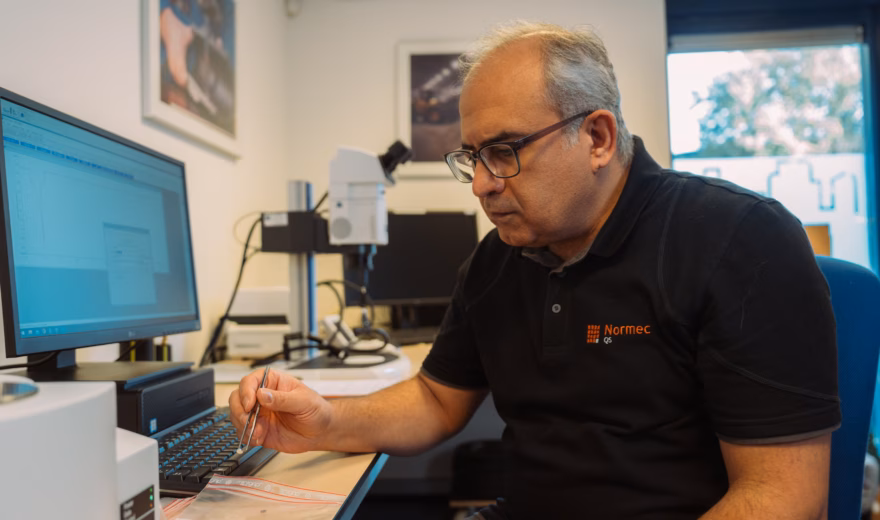 Der Mitarbeiter führt an einem Arbeitsplatz präzise Messungen oder Analysen mit Laborgeräten durch.