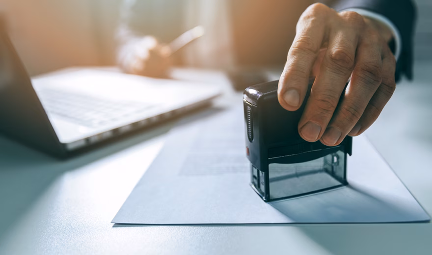businessman put a stamp on business contract in office