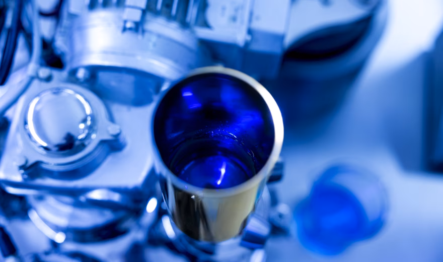 Nahaufnahme einer pharmazeutischen Produktionsanlage mit einem Edelstahltank, der eine blaue Formulierung enthält, wobei der Schwerpunkt auf der galenischen Entwicklung, der Arzneimittelformulierung und der präzisen Herstellung pharmazeutischer Produkte in einer kontrollierten Laborumgebung liegt.