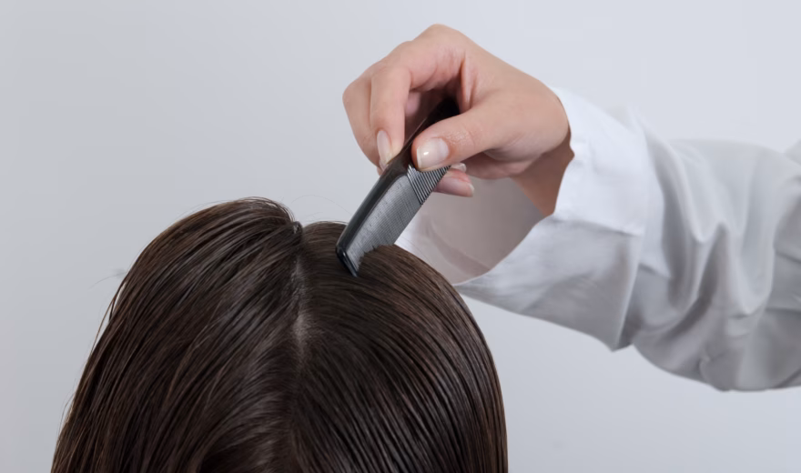 Ein medizinisches Fachpersonal untersucht in einer klinischen Einrichtung mithilfe eines tragbaren Diagnosegeräts die Kopfhaut und das Haar. Im Rahmen dieser Untersuchung wird der Gesundheitszustand des Haares beurteilt, eine dermatologische Untersuchung durchgeführt und ein individueller Behandlungsplan erstellt.