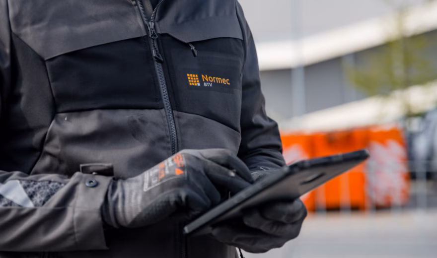 Close-up of an industrial inspector using a tablet to record inspection results and compliance data, highlighting digital inspections, asset management, regulatory compliance, quality assurance, and efficient reporting processes for industrial equipment and workplace safety assessments.