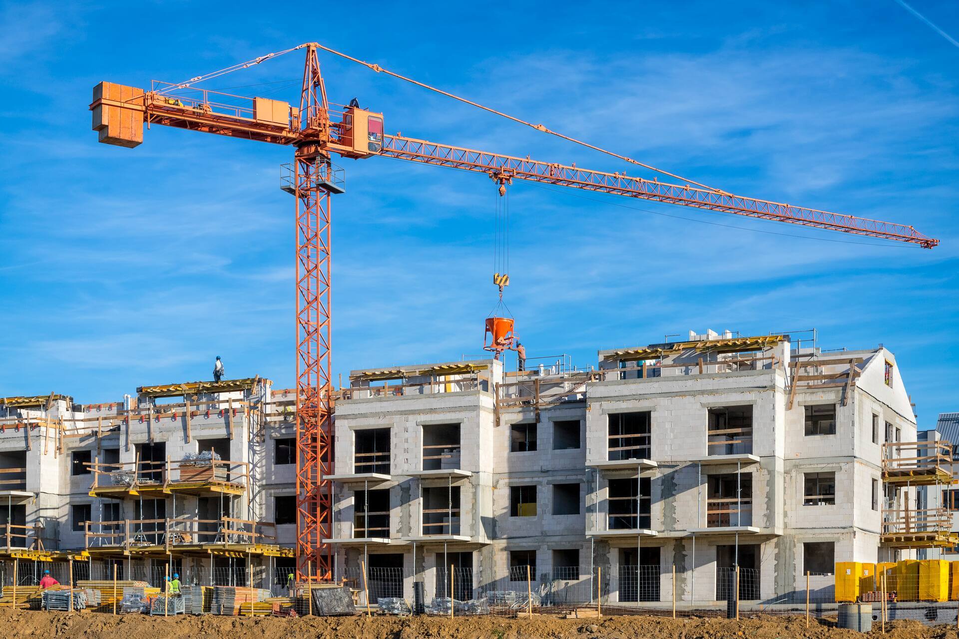 Nieuwbouwproject met appartementencomplexen in aanbouw en torenkraan op actieve bouwplaats.
