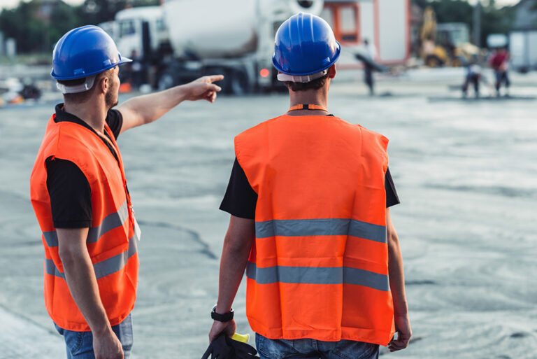 Workers wearing safety gear and hard hats on a construction site during work and work coordination