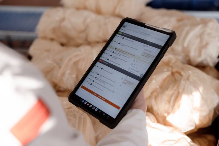 A tablet displays a digital form while being used in a healthcare or home setting.